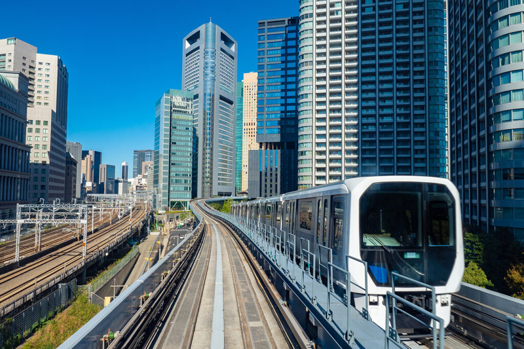 Japan. Tokyo. Train in downtown Tokyo. Public transport in Japan. Transport infrastructure of Tokyo. Multilevel transport routes. Multi-storey office buildings. Modern architecture. Urbanistics.